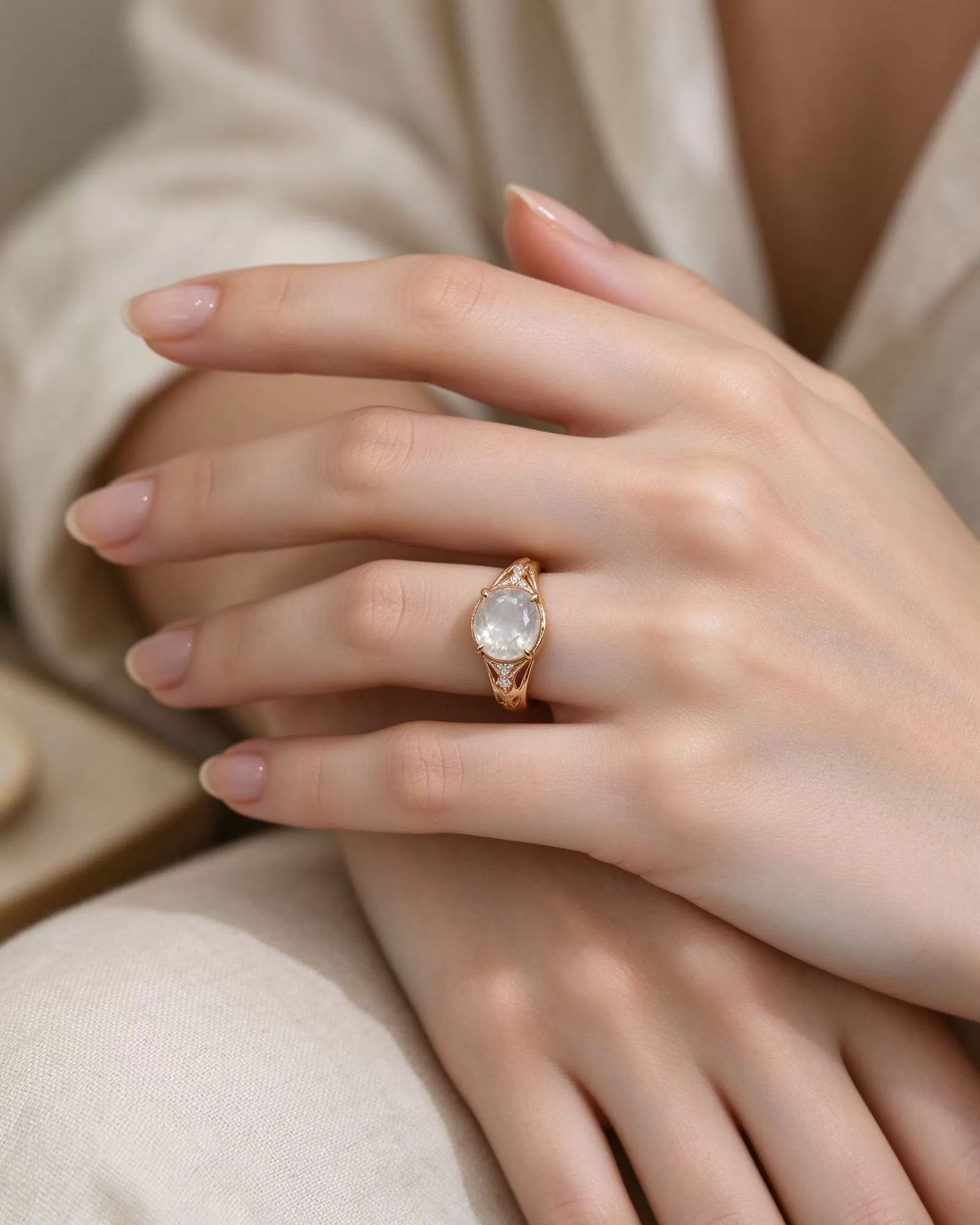 Hands resting together, a simple engagement ring visible